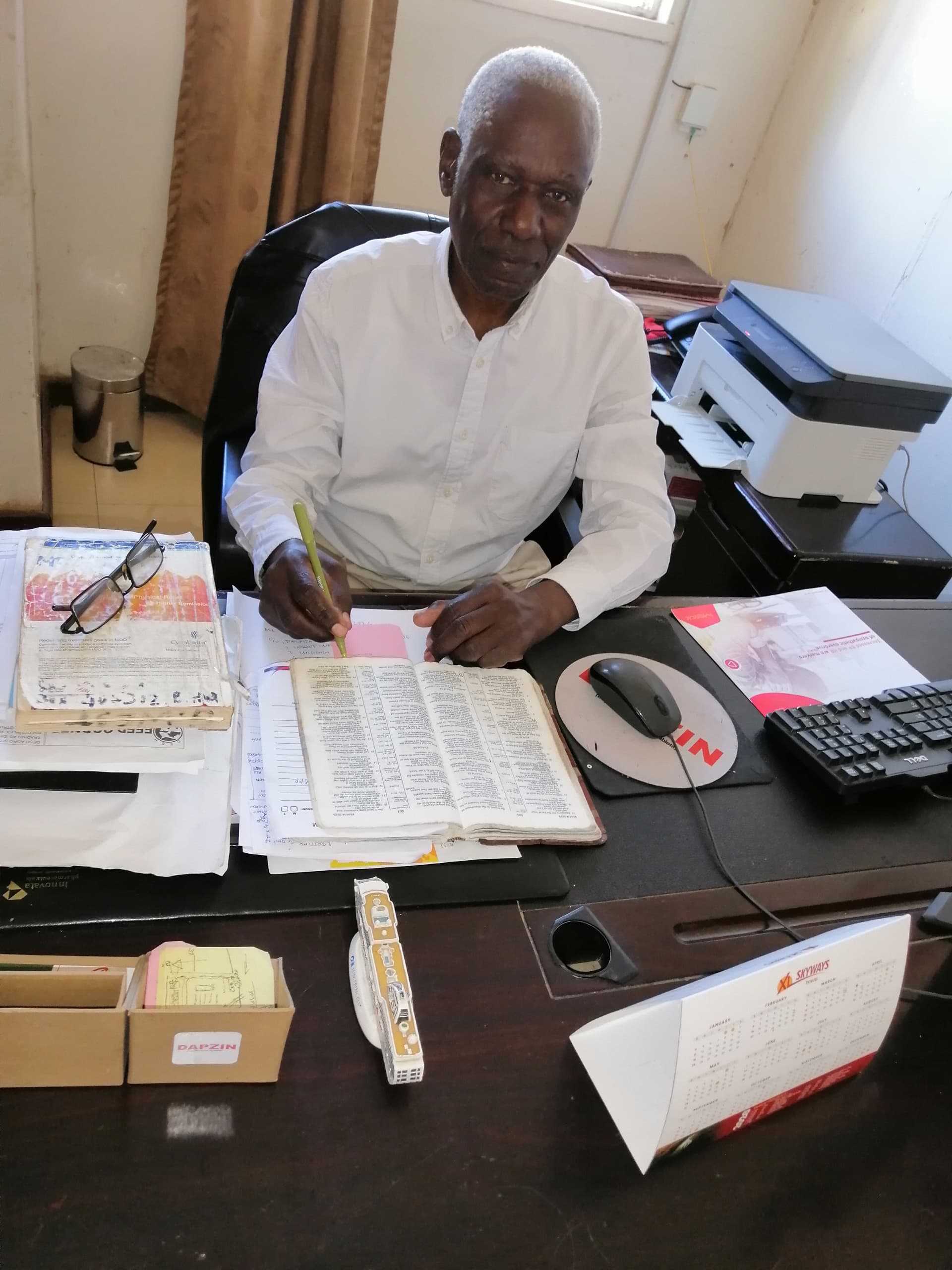 Dr. Francis Edhonu-Elyetu at his desk in MT. Sinai Medical Clinic